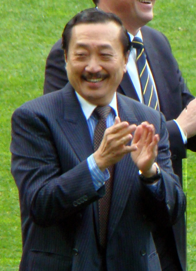 Vincent Tan Chee Yioun, Malaysian businessman and majority owner of Cardiff City FC, smiling and applauding outdoors in