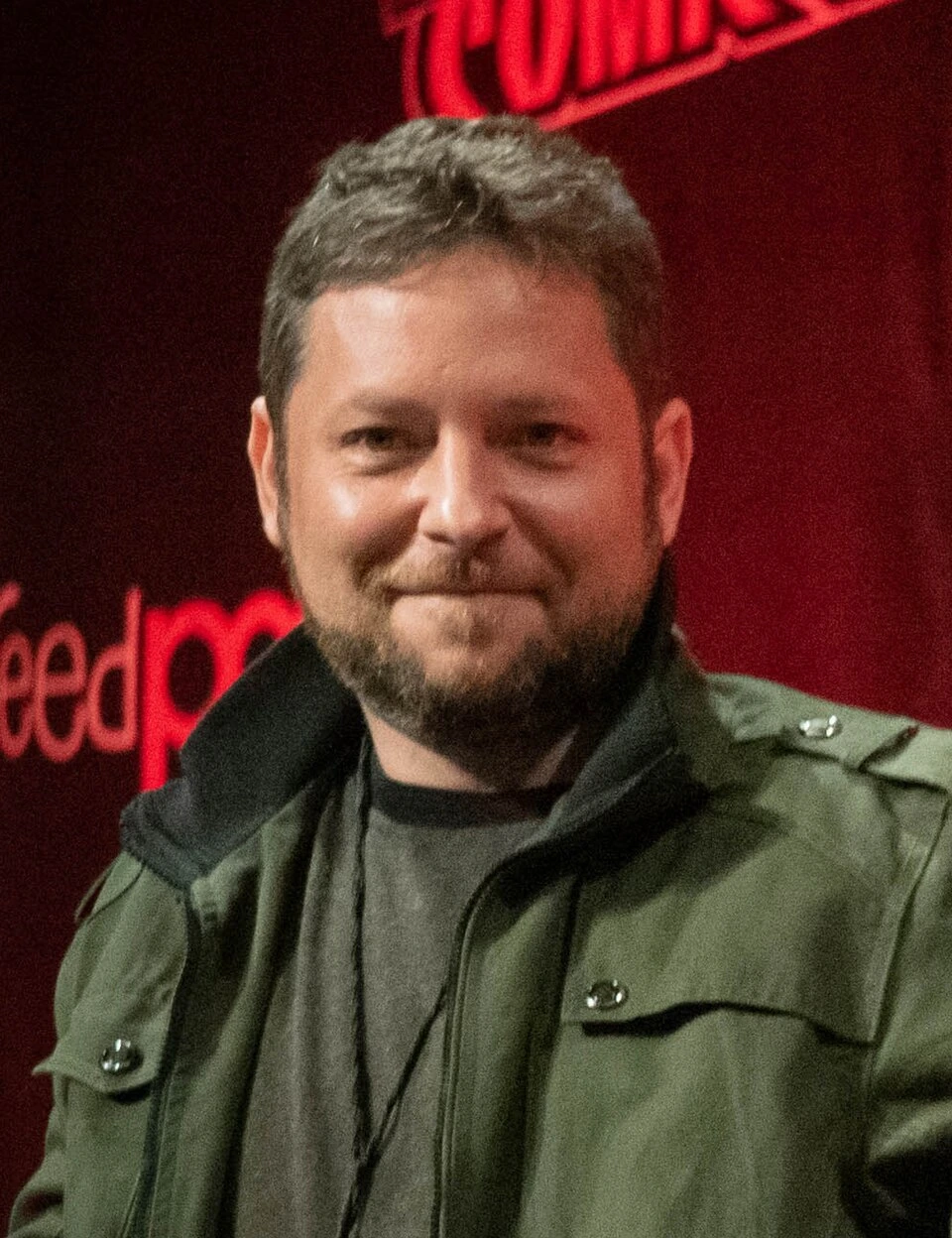 Alex Vincent at New York Comic Con 2021, posed portrait with a red event backdrop.