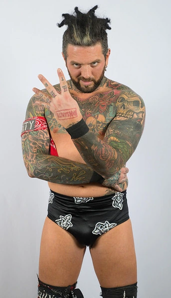 Portrait of wrestler Vinny Marseglia posing in ring gear against a plain background.